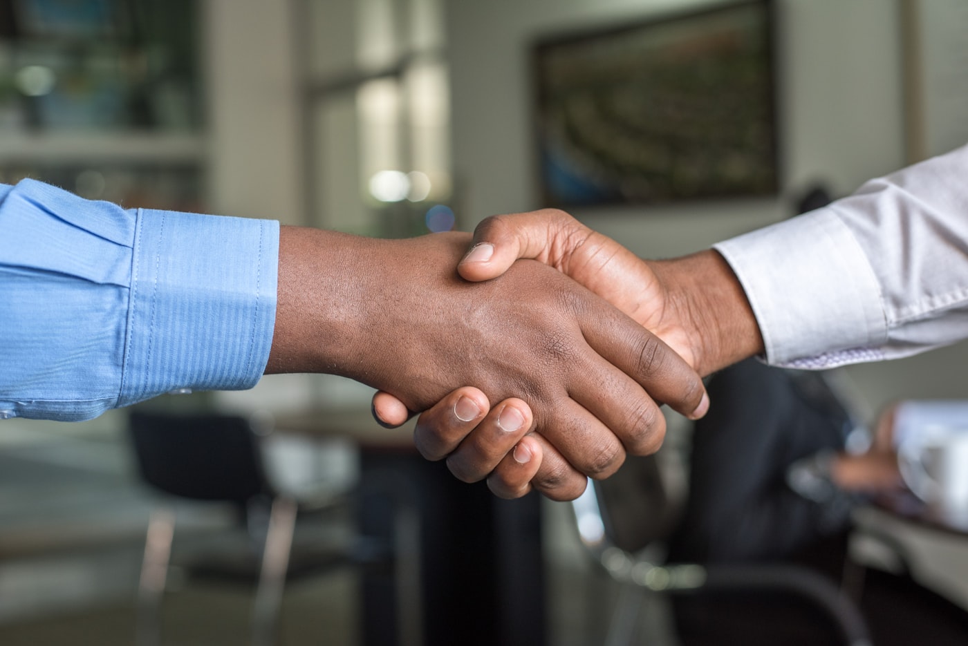 Business owner and client shaking hands after winning new business